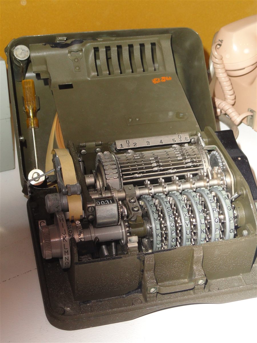 An M-209 portable cipher machine with its lid open.