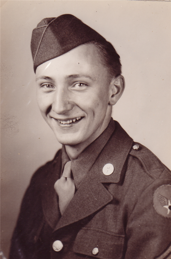 Studio portrait of Cpl. Arthur M. Yena in uniform and garrison cap, smiling, around 1943.